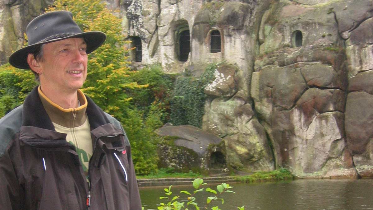 Götz Uwe Kreß an den Externsteinen im Teutoburger Wald mit dem Steinsarg am Wasser.